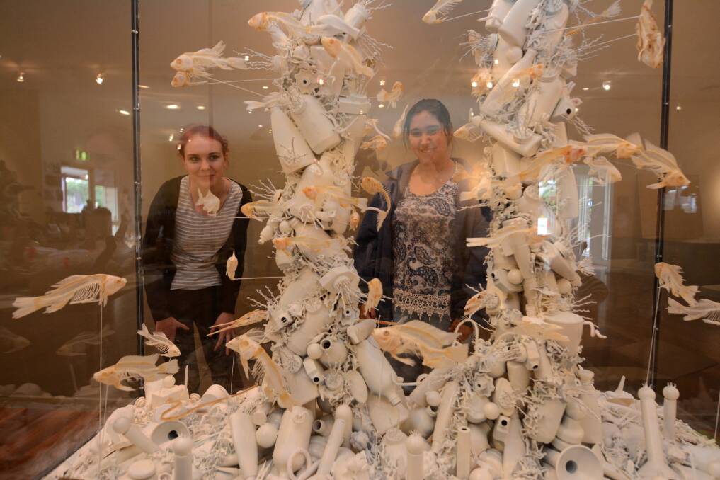 Sarah Crook and Keisha Mitchell view The End of Nature, where artist Rod McRae has combined plastic and bones and coloured them white to highlight the bleaching of the world's coral reefs as well as plastic waste pollution in the oceans.