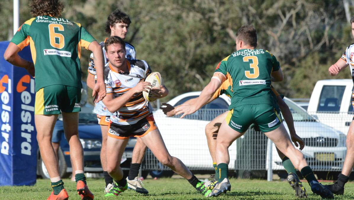 Wingham captain-coach Kurt Lewis tries to weave through Forster-Tuncurry defenders during the last round Group Three Rugby League clash. 