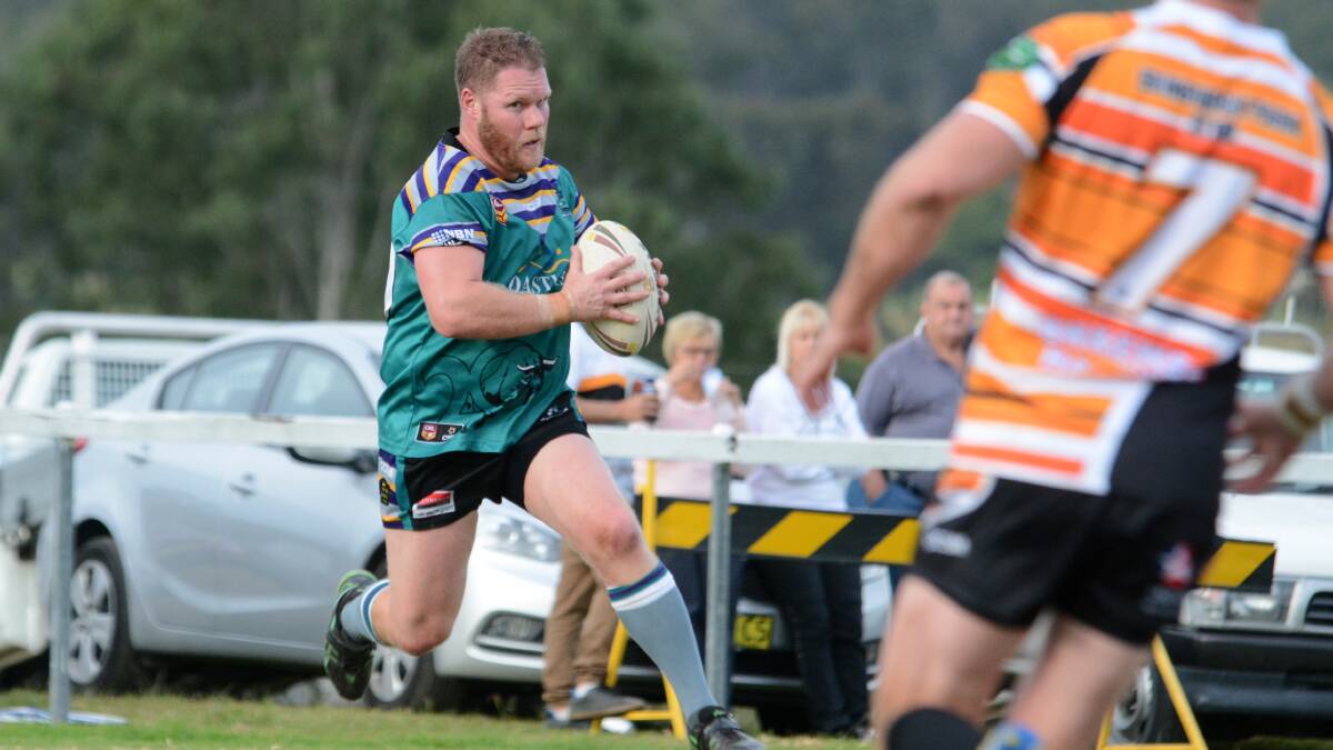 Taree City's Ash Currey charges at the Wingham defence during the first round clash at the Wingham Sporting Complex.
