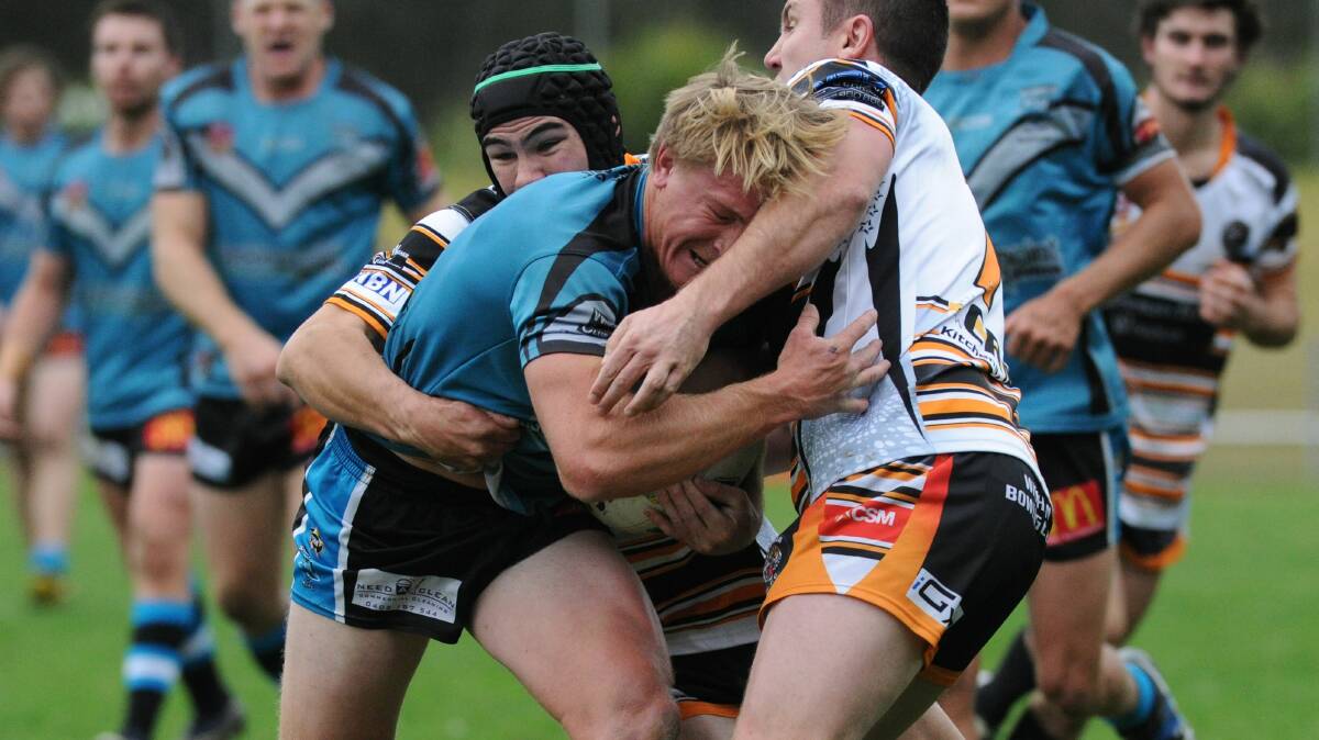 Wingham defenders stop Port Macquarie fullback Harley Gore's progress in the Group Three Rugby League game played at Port Macquarie The Sharks won 42-24.