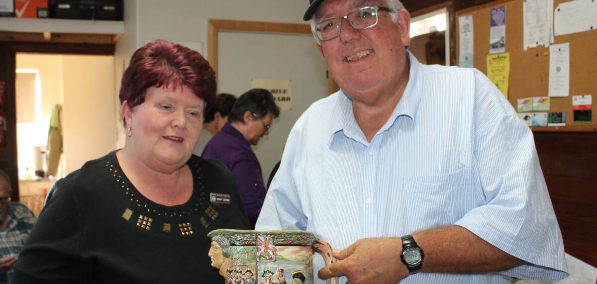 Authentic: President Jenny Cherry admires Tinonee Historical Society AGM guest speaker Rex Nicoll's Royal Doulton anniversary jug.