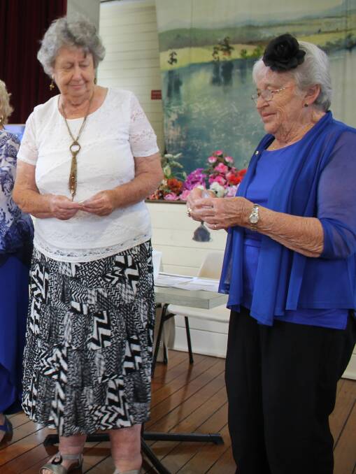 Tinonee Red Cross member Mrs Helen Kerville receives her 30-year Bar and Patrons Badge at the Melbourne Cup Day luncheon, from Mrs Noreida Fotheringham. 