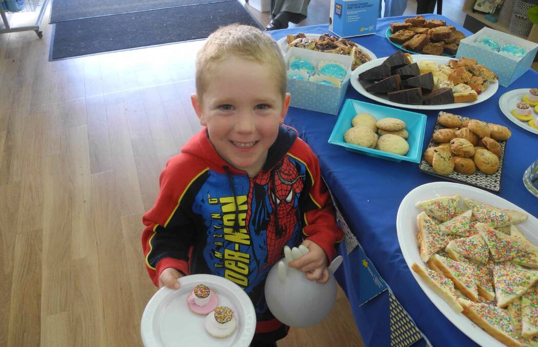 Mitchell Cole enjoying the treats at the 2015 Australia's Biggest Morning Tea at Chapman and Wood pharmacy in Wingham.