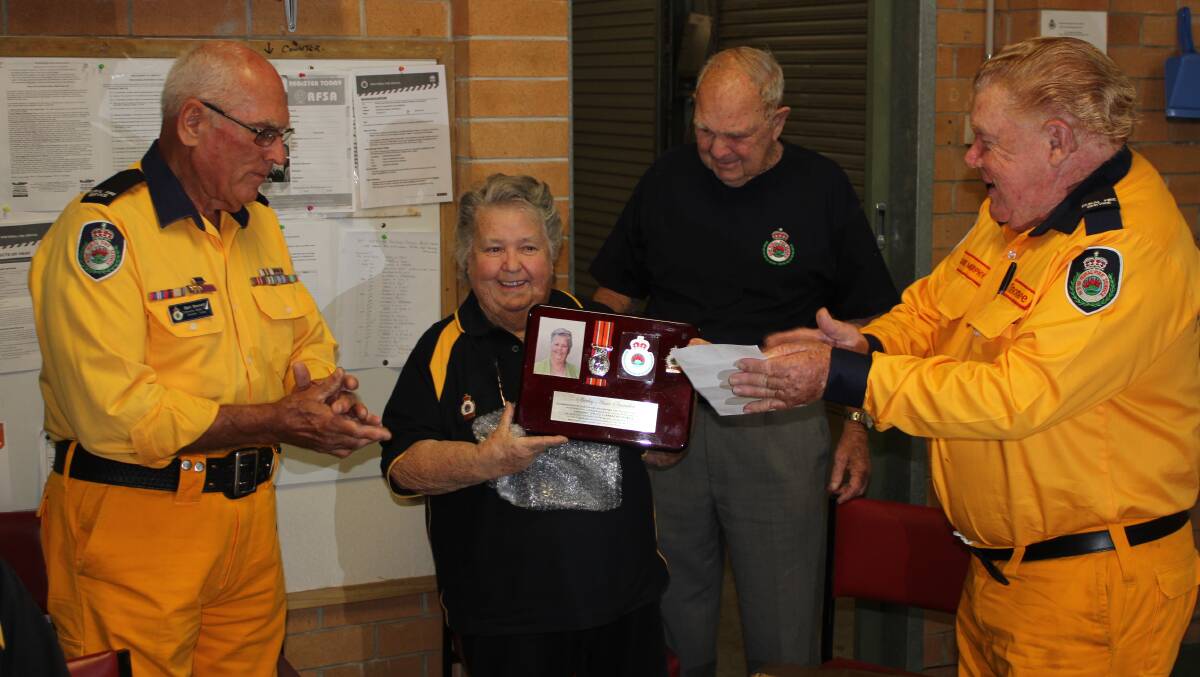 Well deserved: Shirley Snowden being presented with her plaque for her dedication to the Tinonee RFS, with husband Bill, and Bert Bennett and Laurie Murphy. Picture: supplied