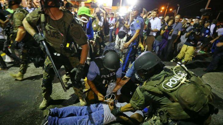 Baghdad or Missouri?: Khaki-clad police officers apprehend a man in Ferguson during this week's protests. Photo: Curtis Compton