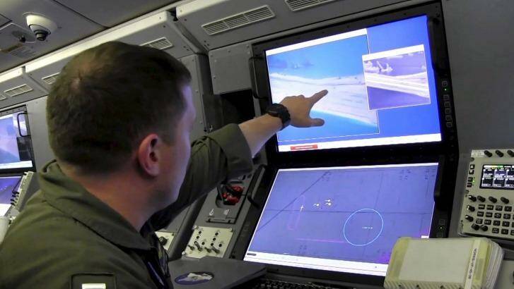 A US Navy crewman aboard a P-8A Poseidon surveillance aircraft views a computer screen purportedly showing Chinese construction on the reclaimed land of Fiery Cross Reef in the disputed Spratly Islands in the South China Sea. Photo: US Navy