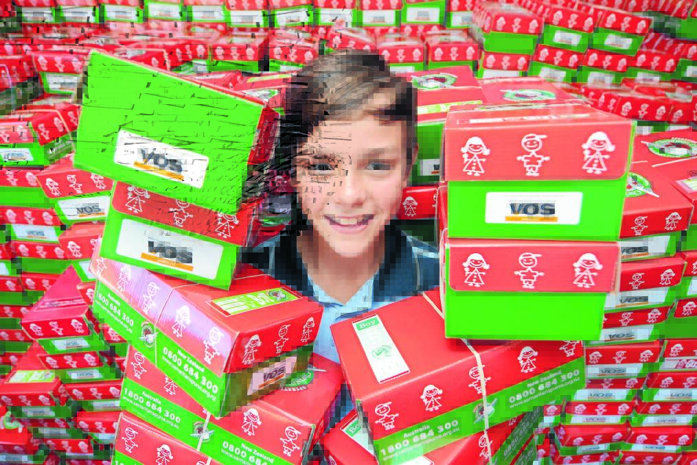 An abundance of boxes: Jake Charlton of Taree Christian College worked with classmates to prepare Operation Christmas Child boxes for collection from Taree Baptist Church.