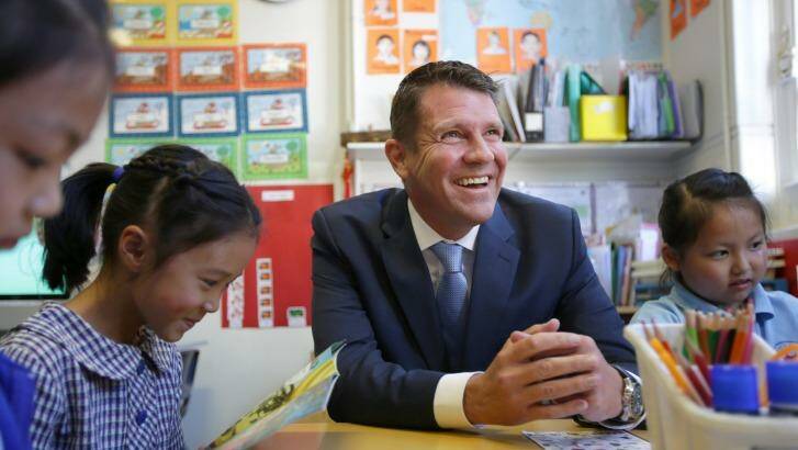 Premier Mike Baird listens to children reading at Hurstville South Public School. Photo: John Veage