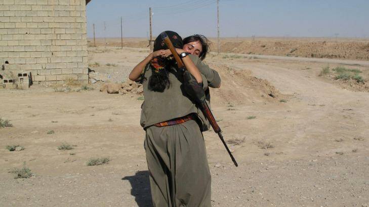 PKK fighters returning to their unit at the Daquq PKK base embrace after a night on the frontline. Photo: Ruth Pollard
