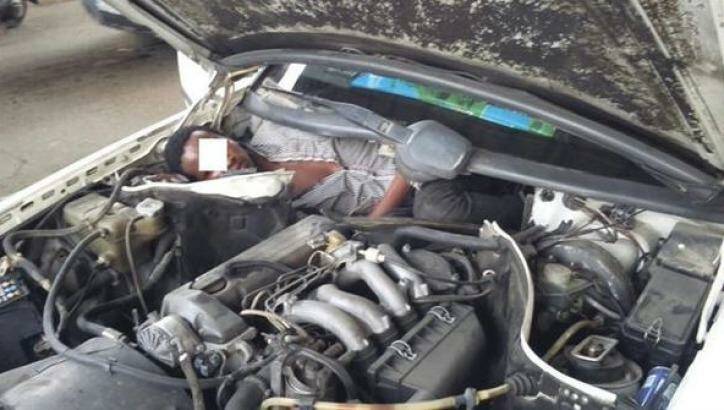 A migrant from Guinea is found hiding in a car engine in a bid to enter Spain from Morocco. Photo: Guardia Civil 