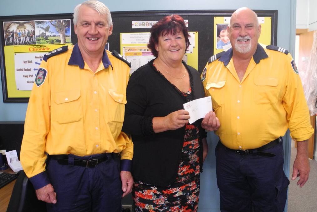 Group Four captain Ian Sirett and Wallaby Joe captain Bob Pope accept a cheque from Elaine Turner of the Wingham Chronicle.