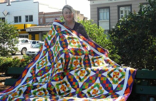 Maggie Young with a quilt donated by MNC of NSW Community Quilters, the major prize in a raffle  to fund the deposit of the hire of Cell Block Theatre at Darlinghurst Gaol in Sydney, where she will stage her play Isabella the Play. 