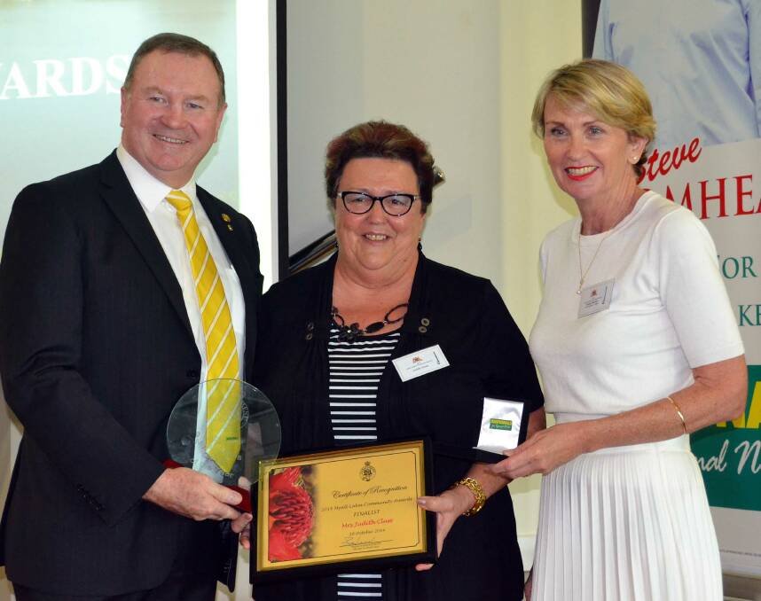 Stephen Bromhead and Wendy Machin present Judy Cluss with her citizen of the year award