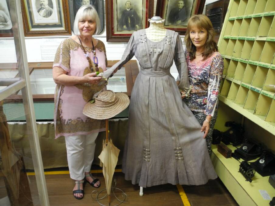 Lyn Catt (left) and Kim Armstrong at the Wingham museum with a grey linen day dress from 1901.