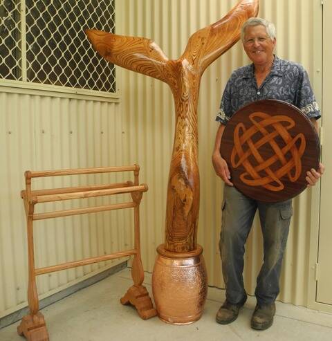 The whale tail commission, with it's sculptor Wingham Men's Shed president Jim Brydon. He is holding another of his works - an inlaid veneered celtic knot lazy Susan made of red mahogany and tallowood.