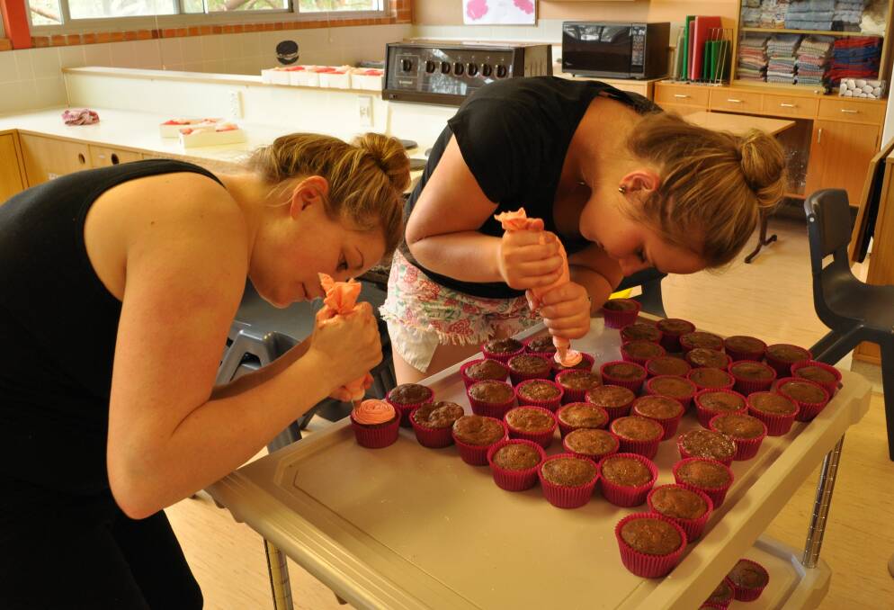 (From left) Kylie Hailes (Julie Bale's eldest daughter) with Cody Waring-Smith preparing the cupcakes.