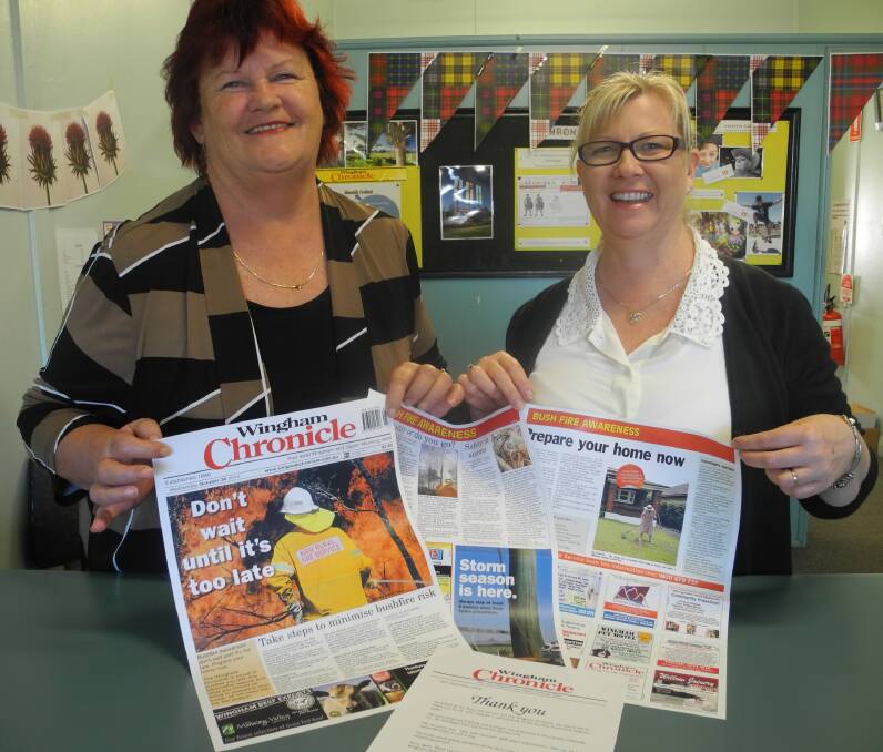 The Wingham Chronicle's sales representative Elaine Turner and sales support administrator Pamela Mann with some of the Fire Awareness campaign pages.