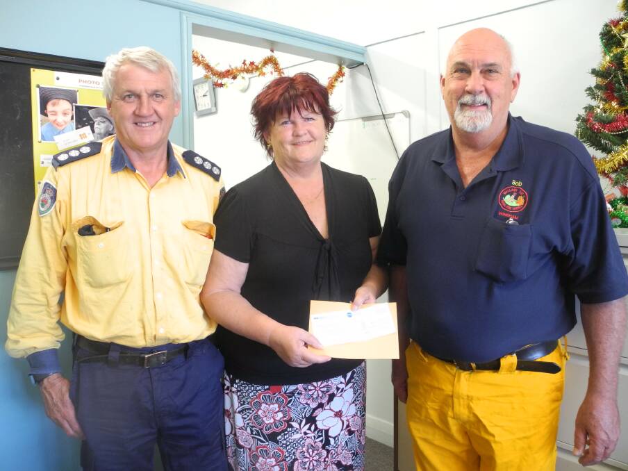 Ian Sirett, Group Four captain and Bob Pope, Wallaby Joe captain, accept a cheque from Elaine Turner of the Wingham Chronicle