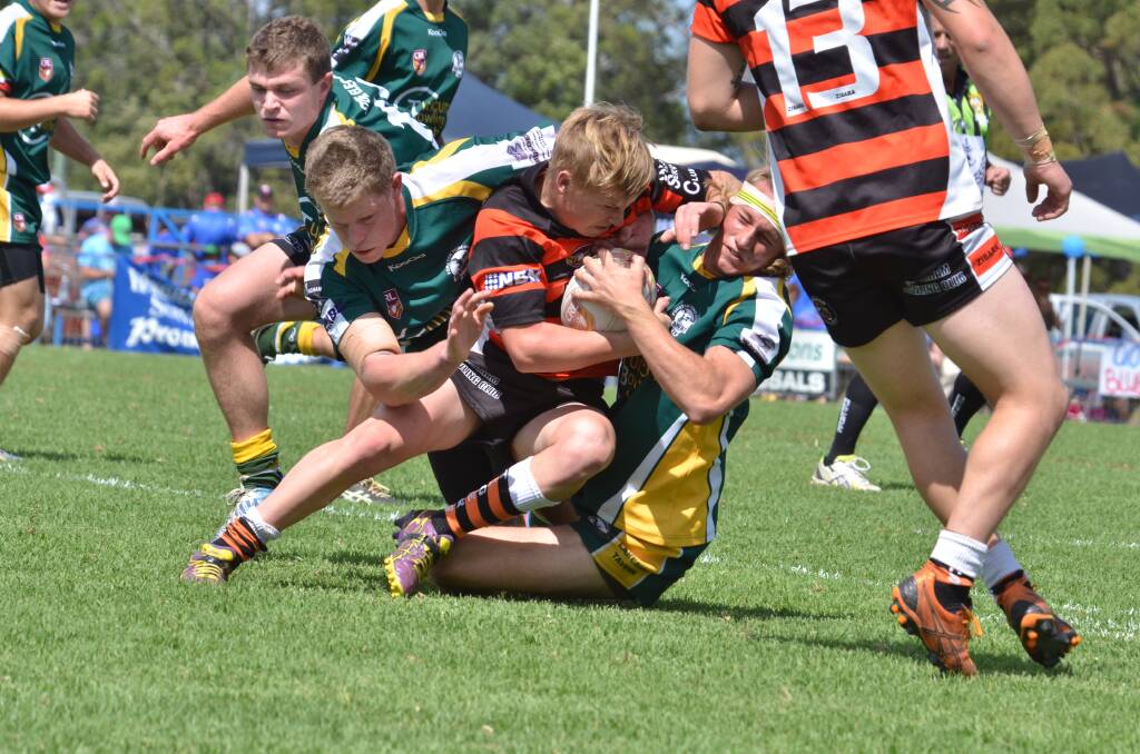 Wingham Tigers under 18's halfback Mitch Collins is wrapped-up by the Forster Tuncurry Hawks opposition during the Group 3 grand final in Wauchope on Sunday. The Tigers went down in this contest.