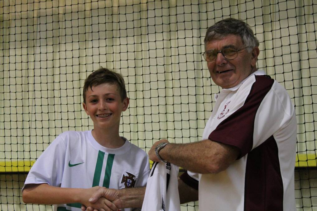 Manning Futsal president Peter Forbes presenting Keegan Hughes with his 'All Stars' shirt