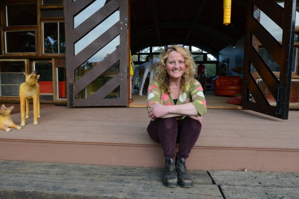 Creative space: Jane Hosking sits on the steps of her art studio The Armadillo, named so because of its shape and Jane's interest in armadillos, and which features corten steel doors at the front.