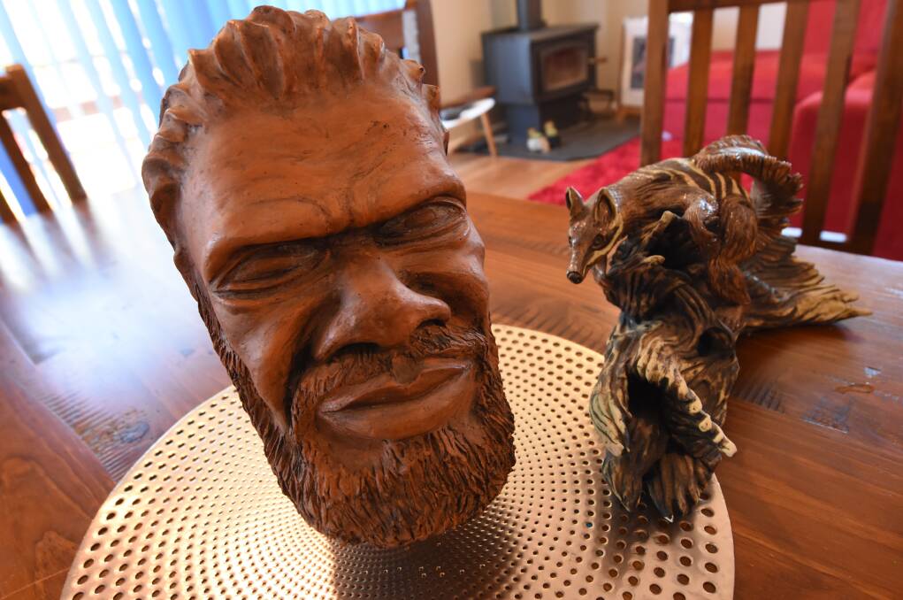 Sculpture: Russell's first clay sculpture of a man's head, and a wood carving of a numbat on a log.