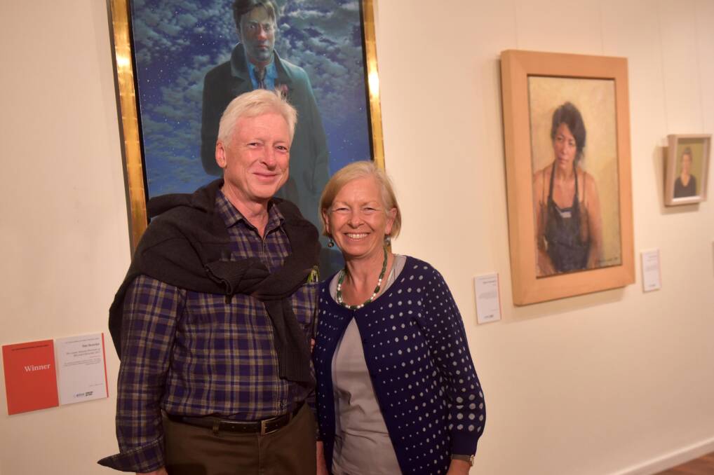 Exhibition: The 2017 Doug Moran Portrait Prize at Manning Regional Art Gallery closes this Sunday. Pictured at the official opening are Roger and Jane Liddle with the winning work, Tim Storrier's 'The Lunar Savant. Photo: Julie Slavin.