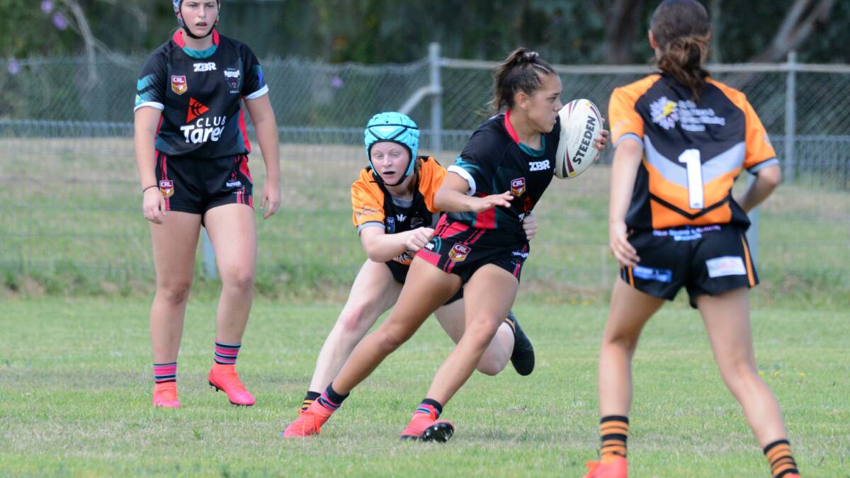 Kashaya Mitchell is taken by a Wingham defender during a match in the North Coast 11-a-side competition played in Taree last month. 