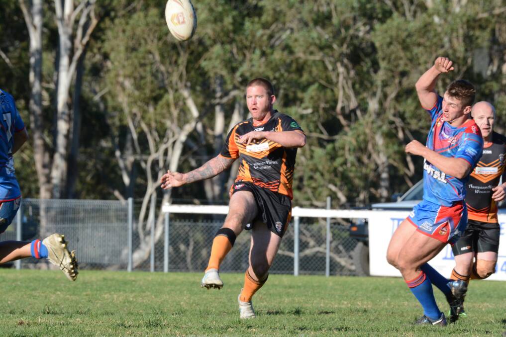 Wingham captain-coach Danny Russell chip kicks in the clash against Wauchope. The Tigers will host Port City on Saturday.