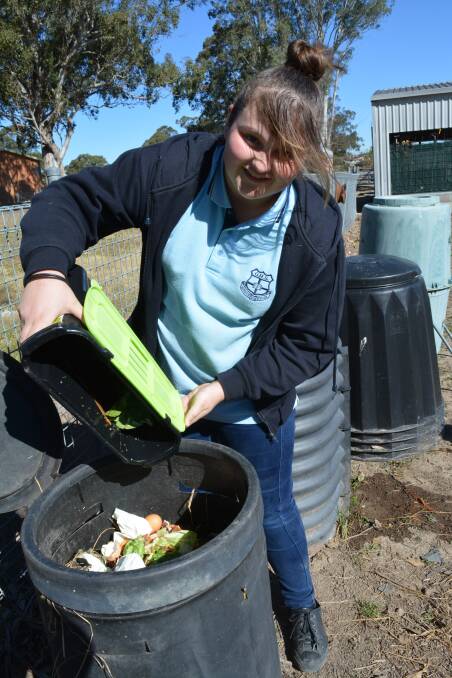 Emily Walker places food scraps into the school's compost bin