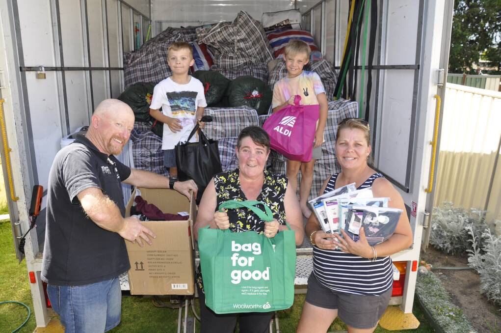 Mission: Kylie Stone (right) with twin sons Ben and Toby, and friends Mick and Sharon Apps packed up the donations ready for the trip to Taree. Photo: Louise Thrower.