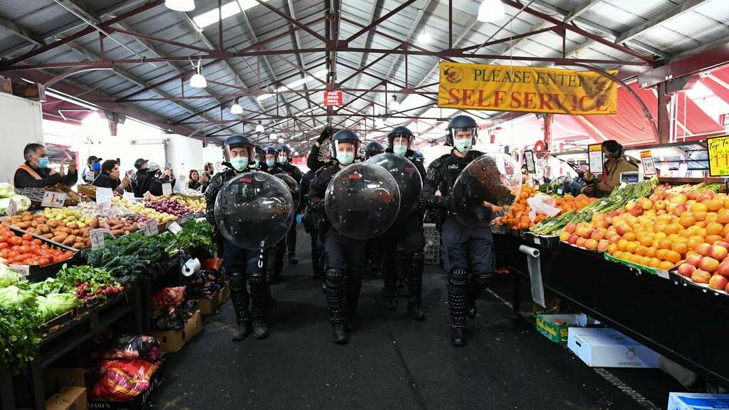Police move protesters on through the Queen Victoria Market during an anti-lockdown protest in Melbourne. Photo: AAP