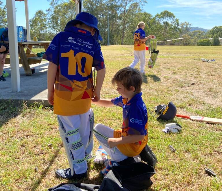 Helping hand: Oliver Barry helping new player Ayden Humphreys get ready to bat. Photo: Supplied
