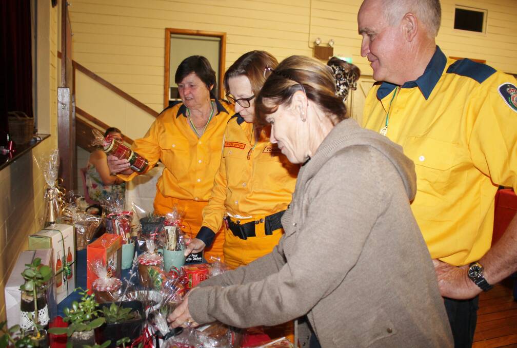  Tinonee Rural Fire Brigade members L to R Sue Odgers, Tracey Dyson, Barry & Lucy Brown selecting their prizes for the best decorated table at the Trivia Night.