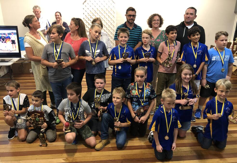 Wingham Junior Cricket Club under 10 team players with their trophies.