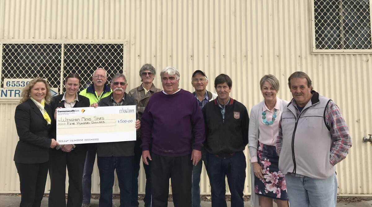 Commonwealth Bank branch manager Dearne Batchelor handing over the cheque to Wingham Men's Shed treasurer Tony Baker. Other members of the men's shed also attended the presentation on Monday.