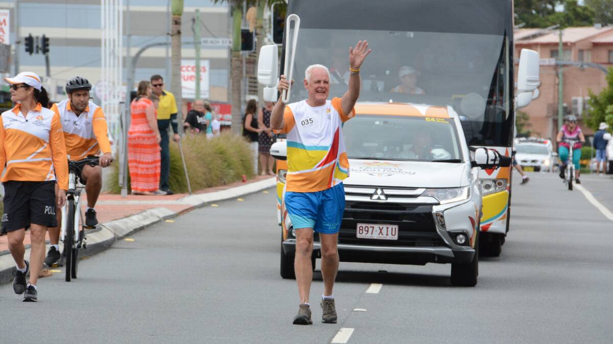 Warren Parr carries the baton in the Queen's Baton Relay in Forster. The baton is making its way to the  XXI Commonwealth Games on the Gold Coast. Photo: Scott Calvin
