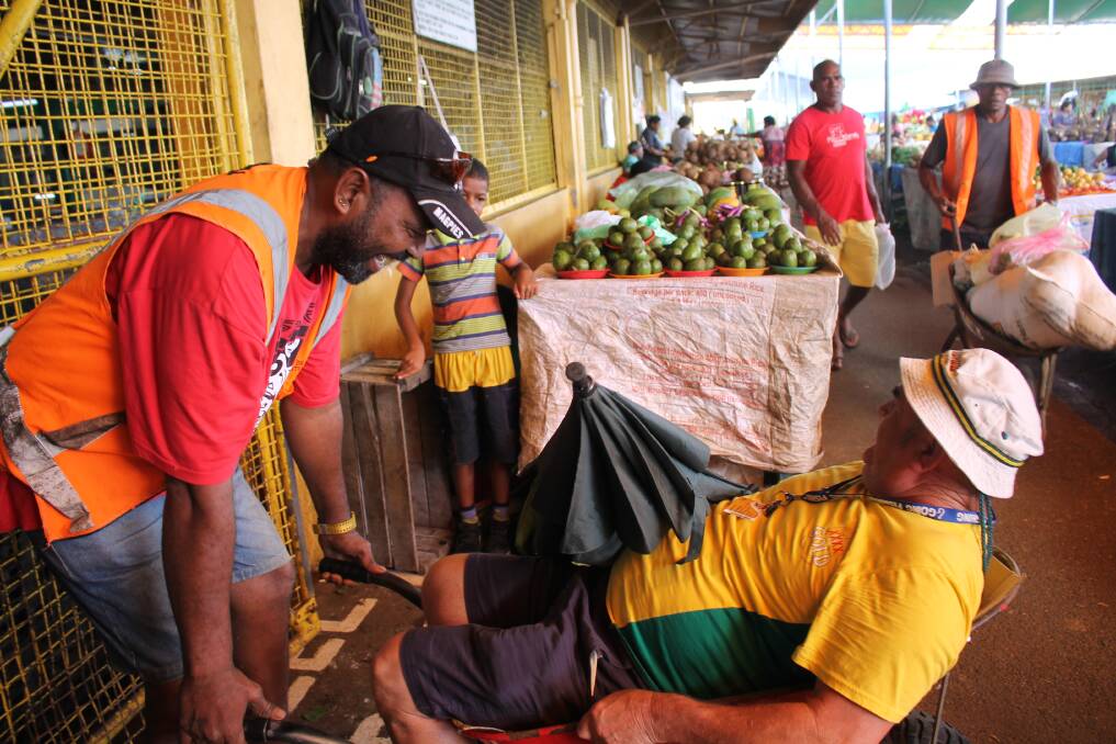 Transportation: A friendly Fijian gives John Muxlow a tour of the Municipal Growers Market Suva in his wheelbarrow.