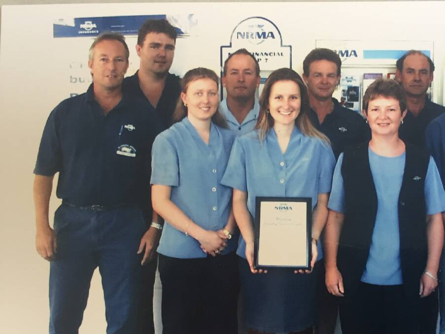 A photo taken around 20 years ago at Manning Smash and Auto Repairs. All of the people in the front row are still working there. Anne is second from the right. Photo supplied