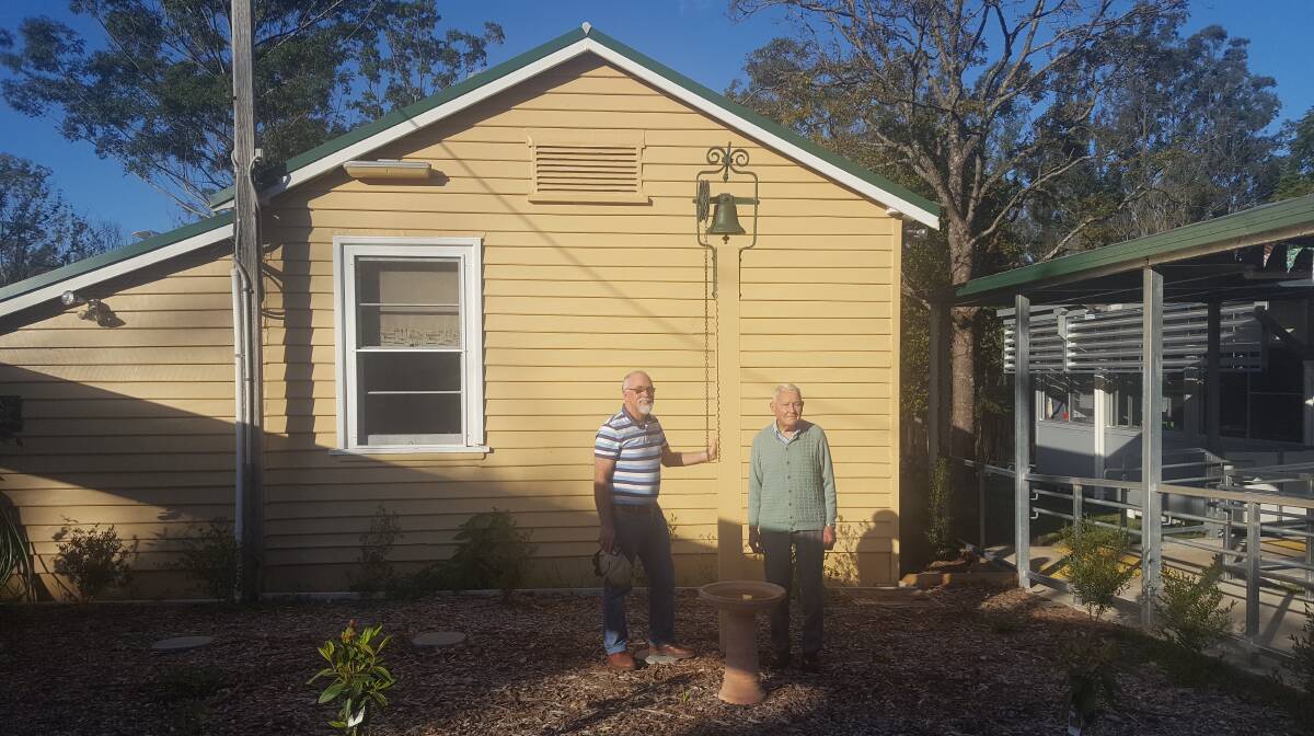 Ray Morrison (right) and son Richard, in front of the Bobin Public School library, the only building left standing after the school was destroyed by bushfire in 2019. Photo supplied