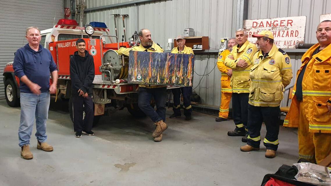Members of Wallaby Joe Rural Fire Brigade with the painting donated by Ron Irwin. Photo: supplied