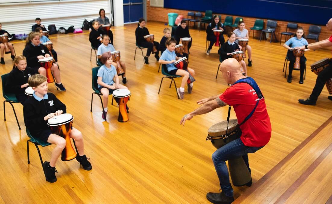 Matt Zarb giving the students a lesson on the djembe drums. Photo: Jake Davey