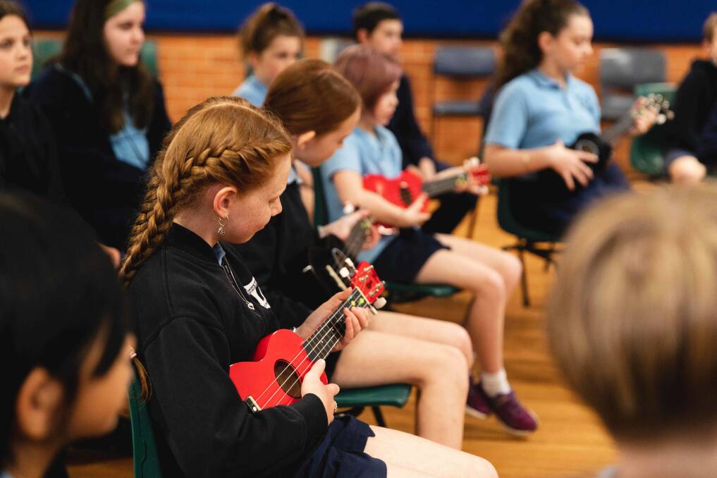 Students having a group lesson in the school hall. Photo: Jake Davey
