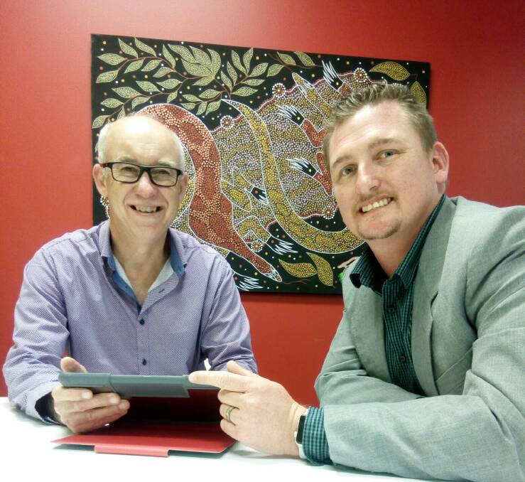 Manager of MidCoast Council Libraries, Chris Jones, discusses the new tech support program with Optus general manager for the Mid North Coast, Chris Simon. Photo supplied