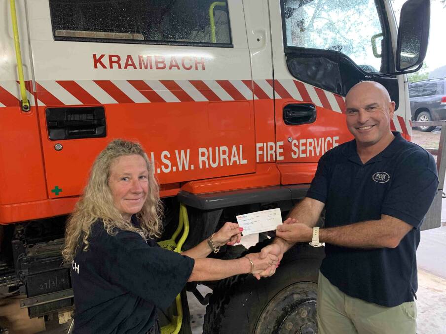 Krambach RFS brigade captain Clare Broniman accepting the donation from Fox Sports soccer commentator Andy Harper. Photo supplied