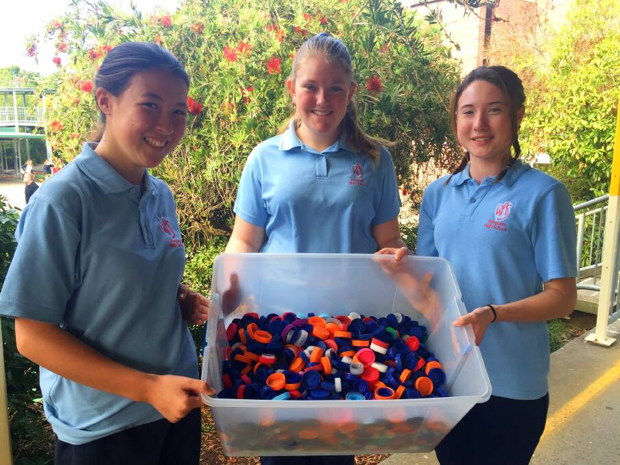 Helping hands: Miranda Frendin, Amber Loretan and Lea Urquhart with the lids they have collected so far. Photo: Julia Driscoll