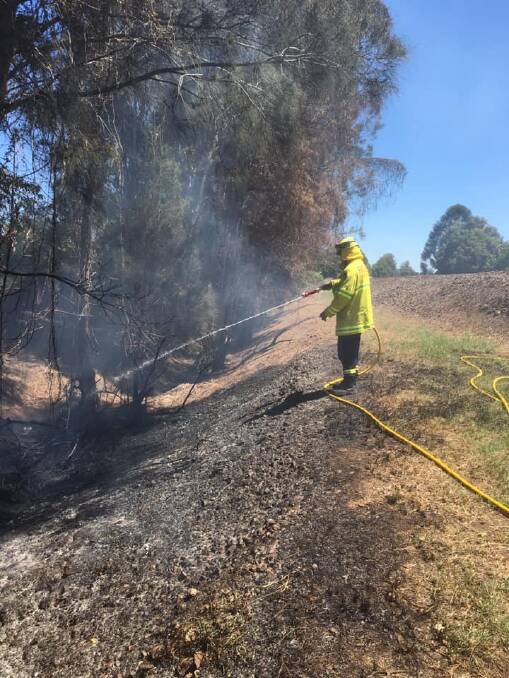 Job well done: A firefighter works to extinguish a grass fire near Myall Avenue, Taree. Crews also put out fires in the vicinity of Railway Street and Kanangra Drive. Photo: NSW Fire and Rescue Taree.