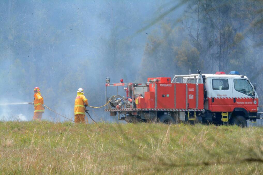 Hard work: Firefighters work to contain a bushfire at Darawank last week. Photo: Scott Calvin.