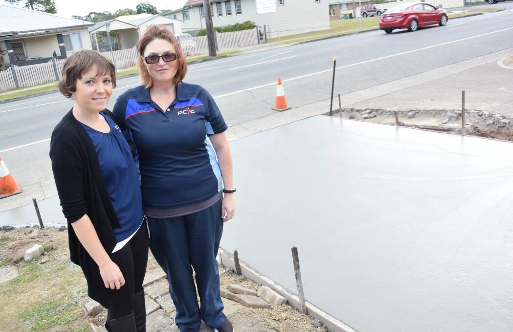Fixing the road: PCYC Taree's Amy Chapman and Donna Lumantas-Hooke at the site of repair works. Photo: Rob Douglas. 