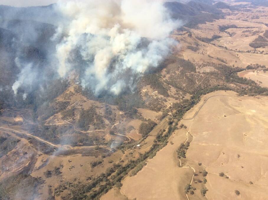 An aerial view of a bush fire on the Thunderbolts Way near Bretti. Photo: NSW Rural Fire Service Mid Coast District Facebook.